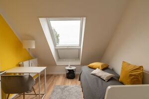 Raum mit Doppelbett und Schreibtisch